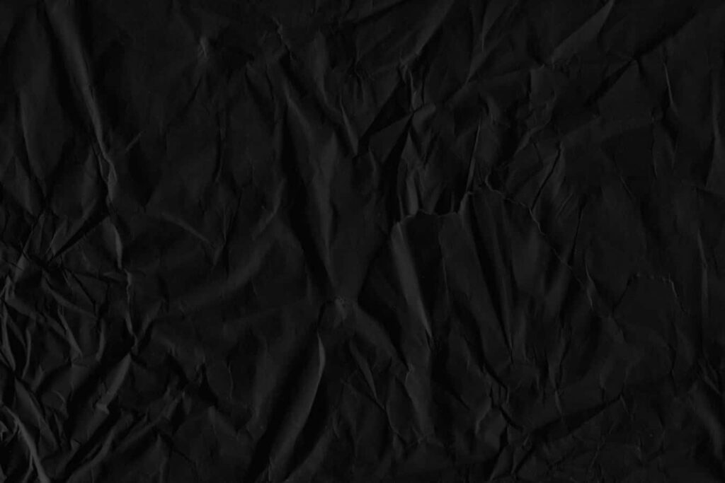 Textured Black Paper Wallpaper: Dark Minimalist Design with Folds