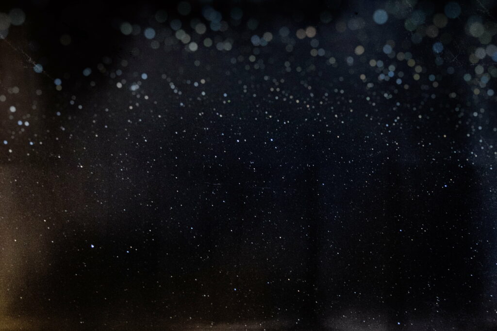 Elegant night sky wallpaper with black texture shimmering white gold stars and bokeh lights