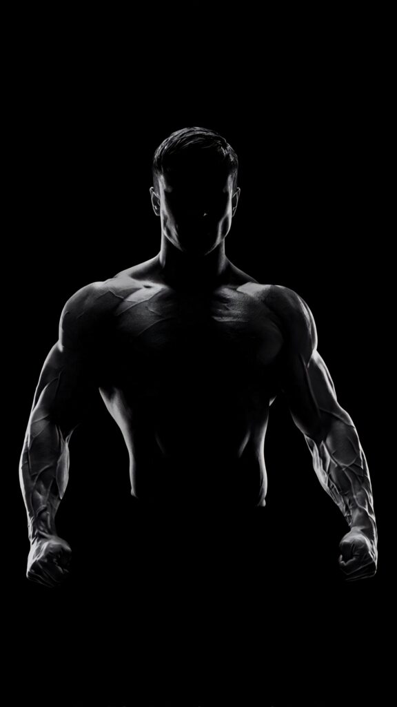 Dark HD portrait of muscular bodybuilder with dramatic lighting highlighting defined muscles Wallpaper