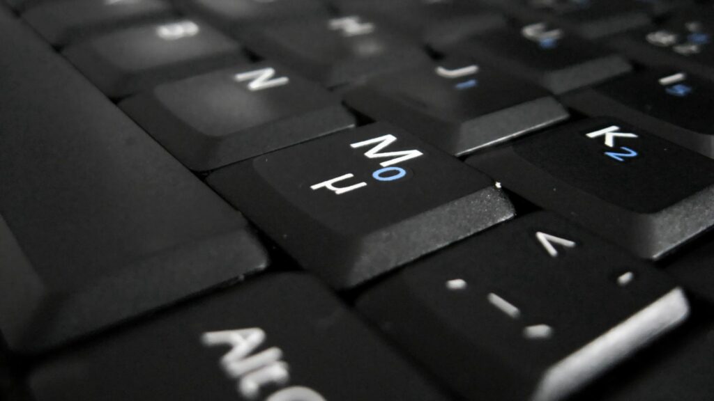 Intricate Dark Keyboard Close-Up: Textured Wallpaper Background