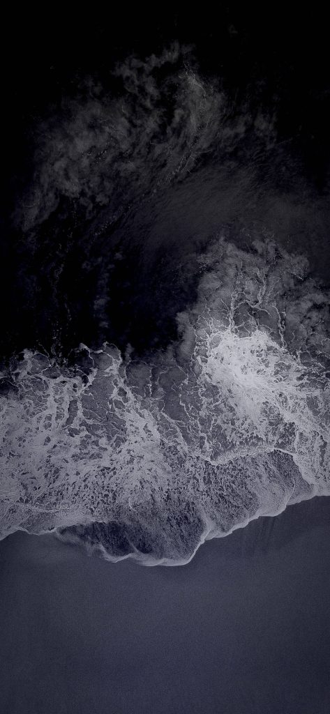 Dark mode mobile wallpaper with aerial ocean waves white foam black water minimalist background