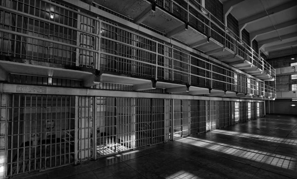 Black and white prison cell block wallpaper with metal bars and dramatic shadows background