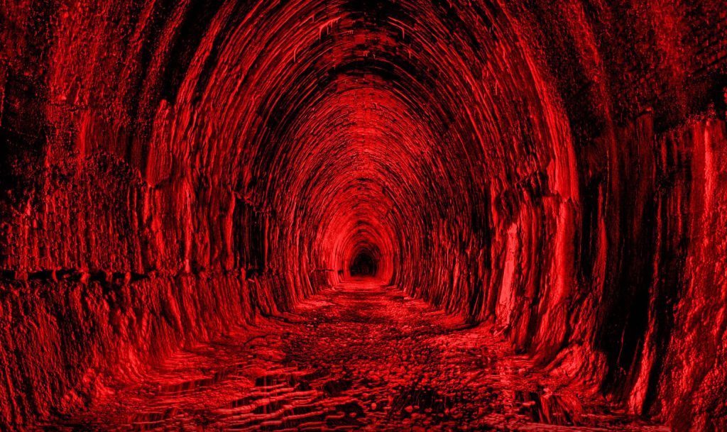 Dark red tunnel wallpaper with rugged cave walls glowing crimson for dramatic backdrop