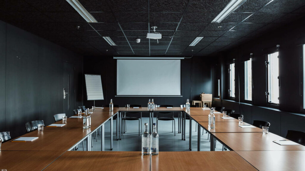 Black Room Brilliance: A Zoom Background with a Sleek Meeting Table and Projector Screen Wallpaper