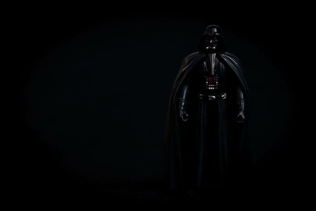 Dark Vader Wallpaper: Ominous Sith Lord Against Black Background