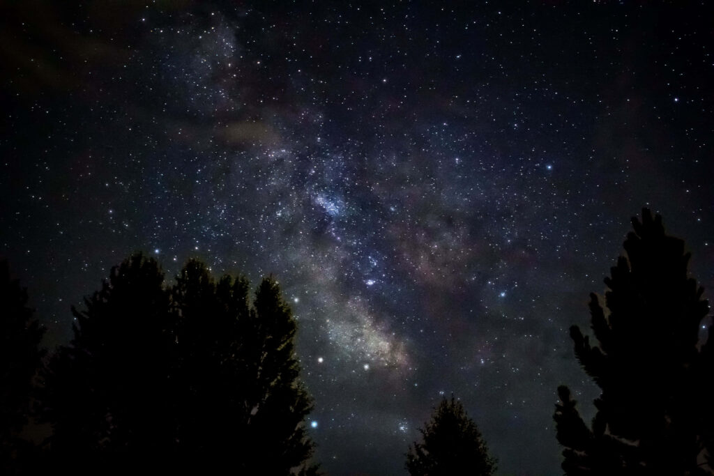 Enchanting Celestial Symphony: Mountain Landscape beneath a Dark Starry Night Wallpaper