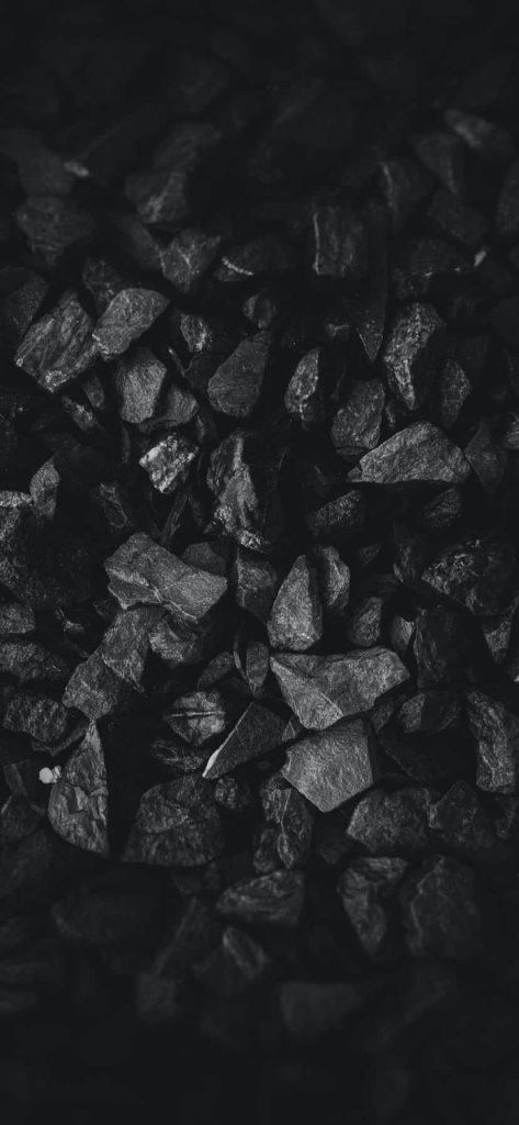Dark stone texture wallpaper with rugged charcoal and slate rocks in high-contrast lighting