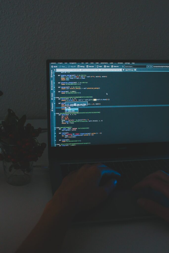 Dark Themed Coding Setup Wallpaper Background with Laptop Screen Code