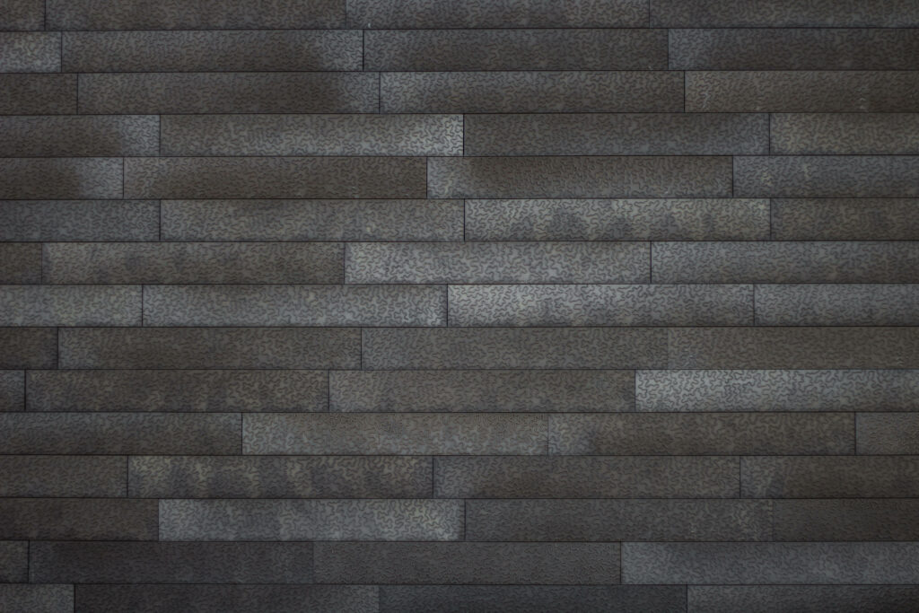 Dark-Toned Long Brick Pattern Shines in Plain Grey Background Wallpaper