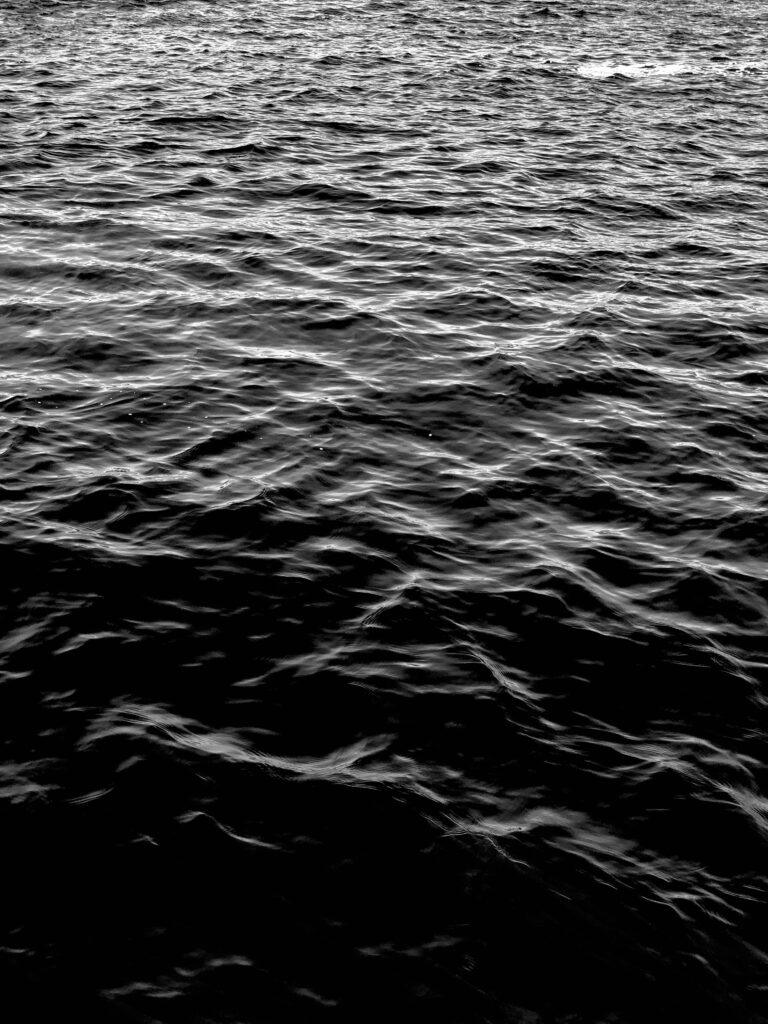 Monochrome dark water wallpaper with intricate waves and ripples creating calming contrast