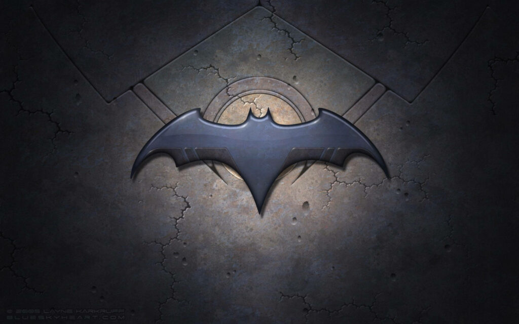 Batman Begins metallic bat symbol on cracked stone background with dramatic spotlight wallpaper