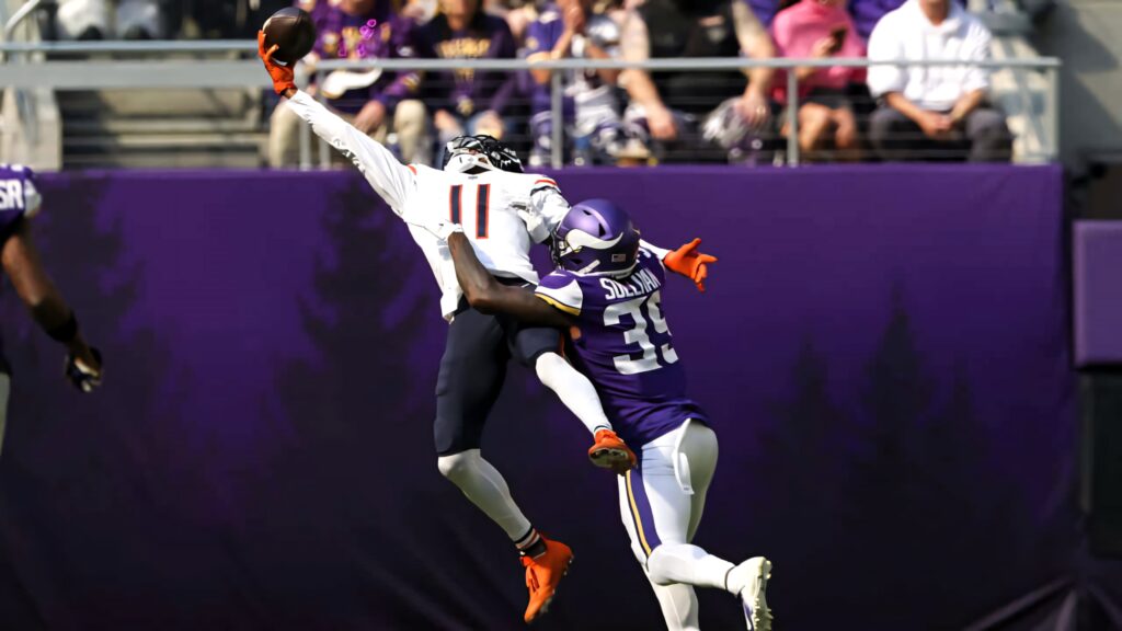 Darnell Mooney mid-air football catch vibrant purple stadium backdrop showcasing agility and intensity Wallpaper