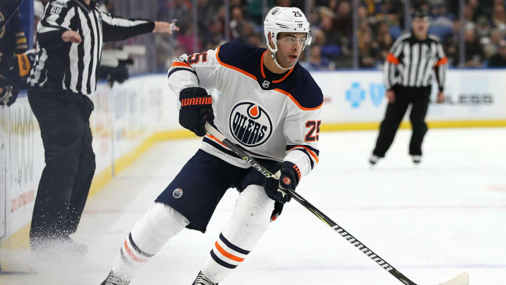 Edmonton Oilers defenseman Darnell Nurse in white navy orange jersey competing against Calgary Flames Wallpaper