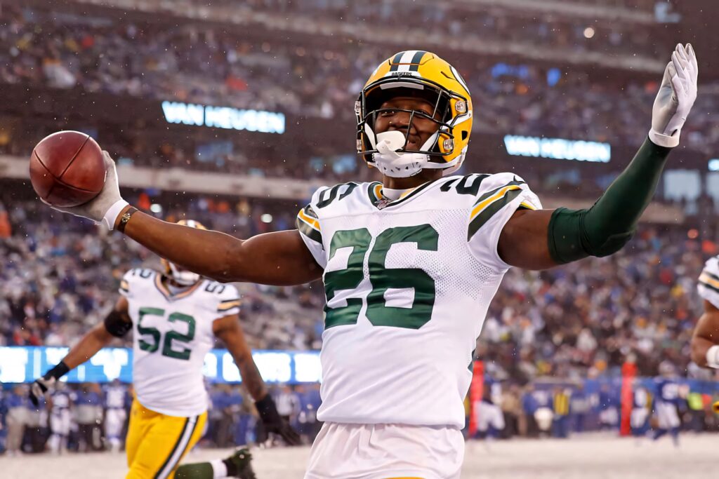 Darnell Savage Jr Green Bay Packers celebrates with football on snowy field in vibrant uniform Wallpaper