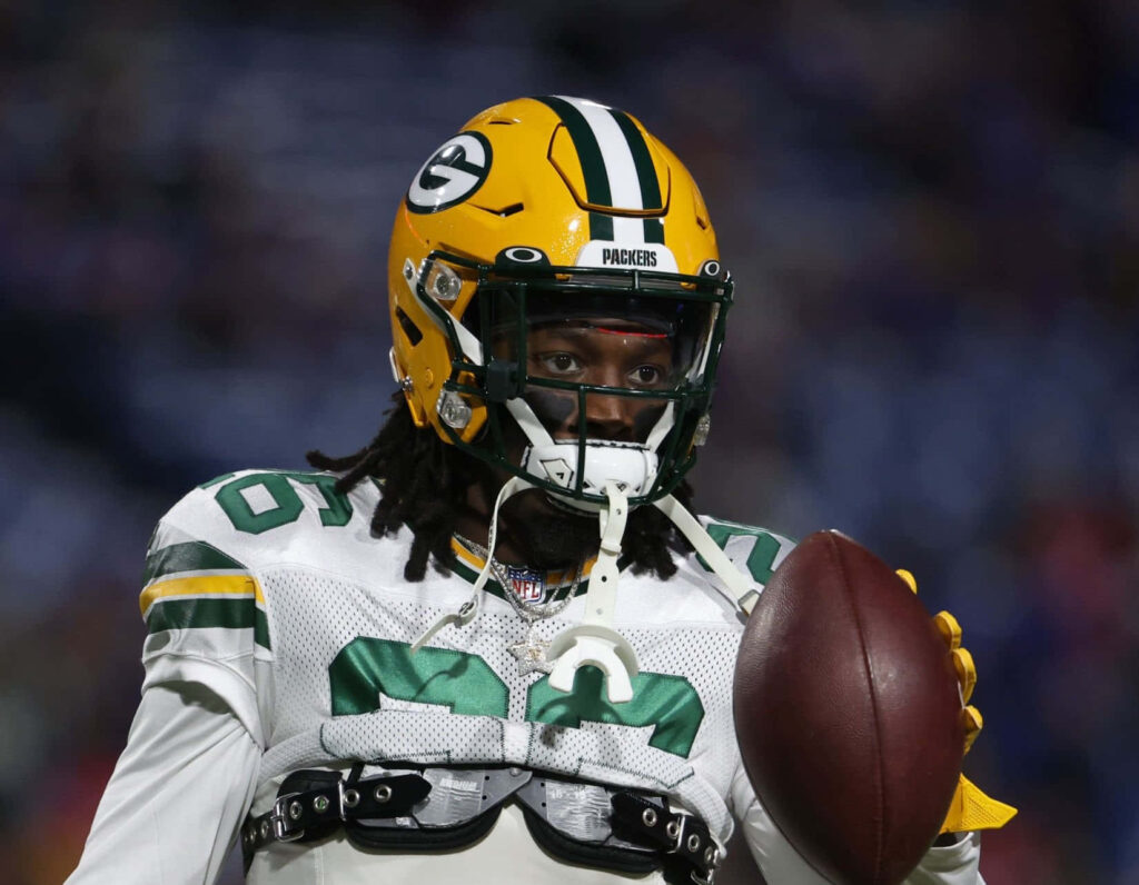 Darnell Savage Jr Green Bay Packers in white uniform and green helmet confidently holding football Wallpaper