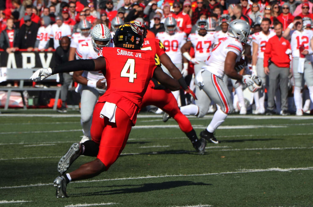 Darnell Savage Jr. in red Maryland jersey number 4 making a dynamic defensive play versus Ohio State Wallpaper