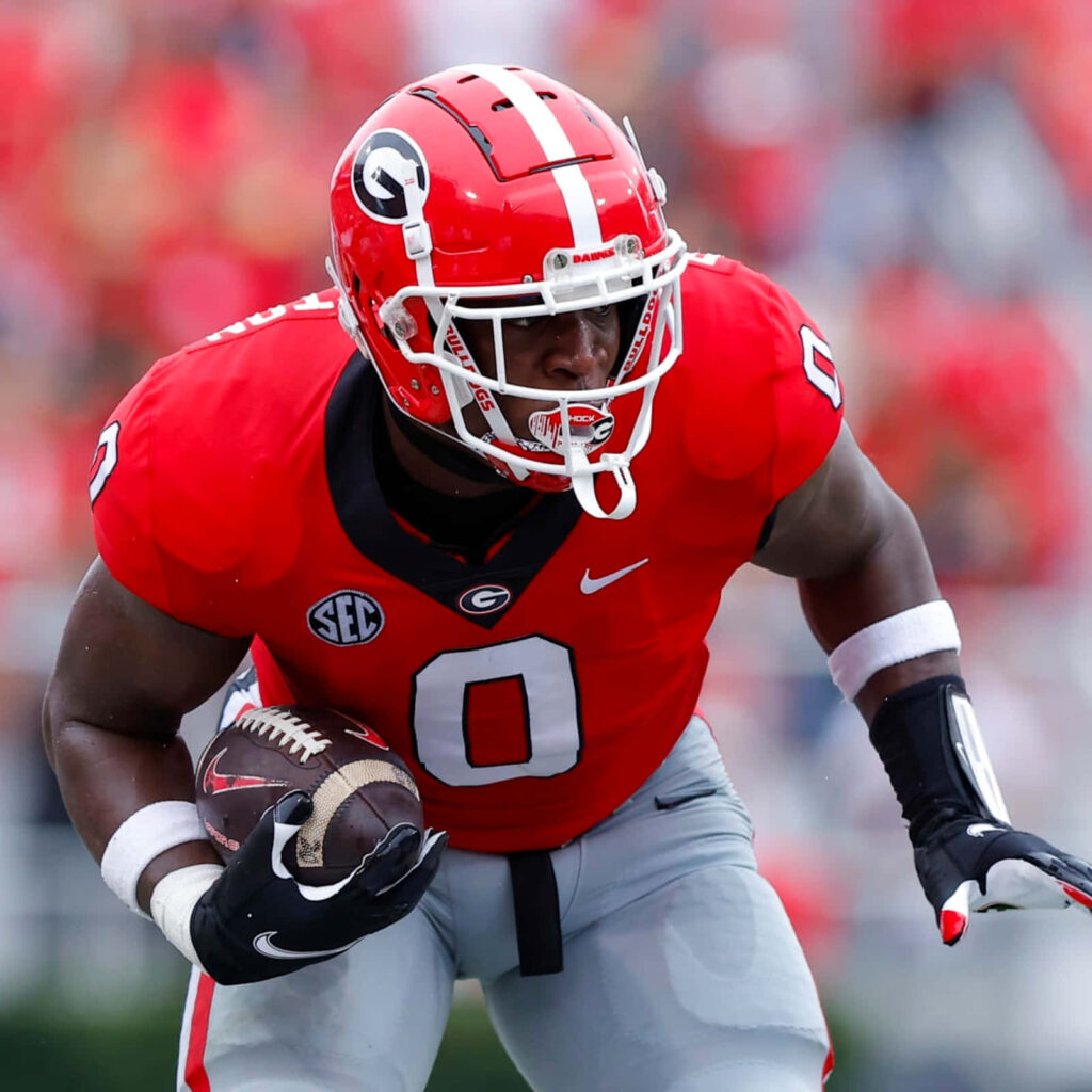 Darnell Washington of Georgia Football in red gray uniform intense action on vibrant field background Wallpaper