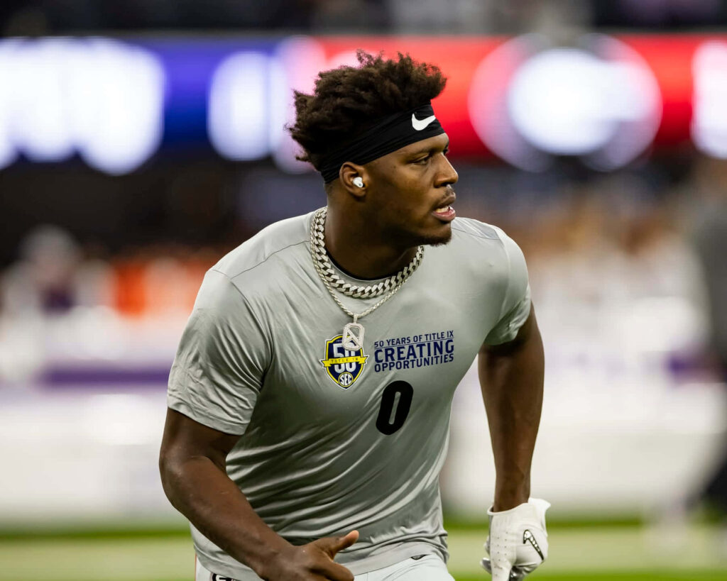 Darnell Washington warming up in gray athletic shirt under stadium lights showing focus and intensity Wallpaper