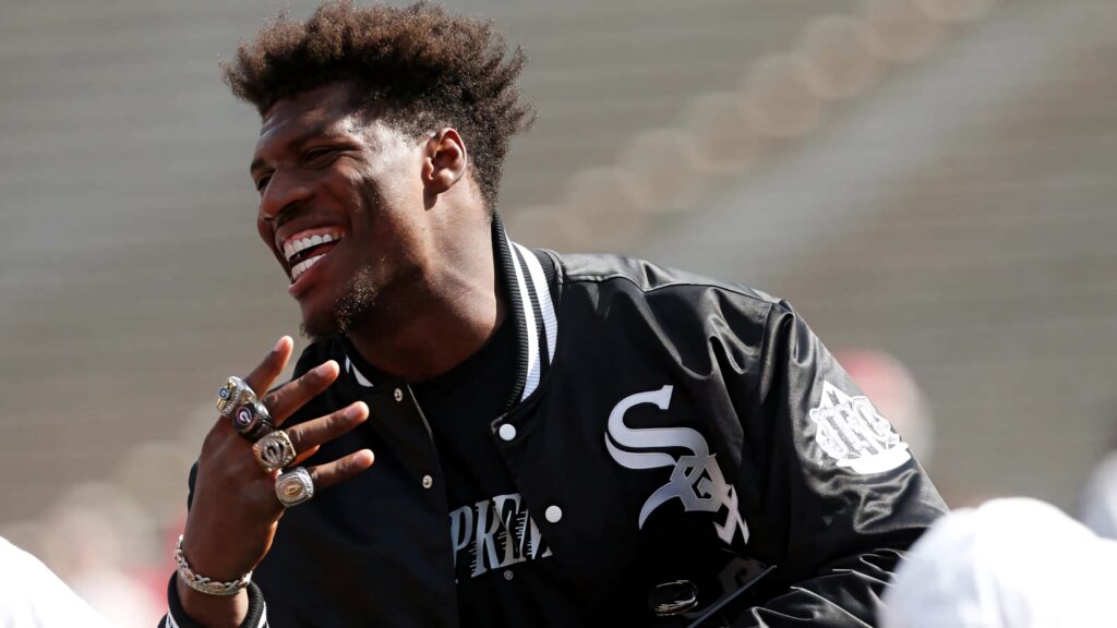 Darnell Washington laughing wearing black jacket and multiple championship rings stadium background Wallpaper
