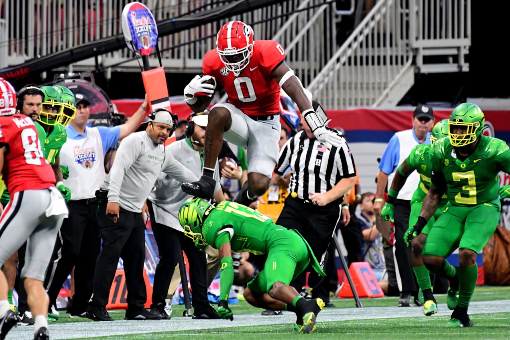 Darnell Washington leaps over defender in Georgia vs Oregon game vibrant football action wallpaper
