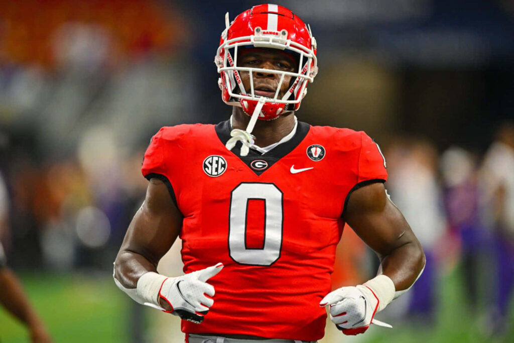 Darnell Washington in red football jersey number zero focused in stadium sports wallpaper background