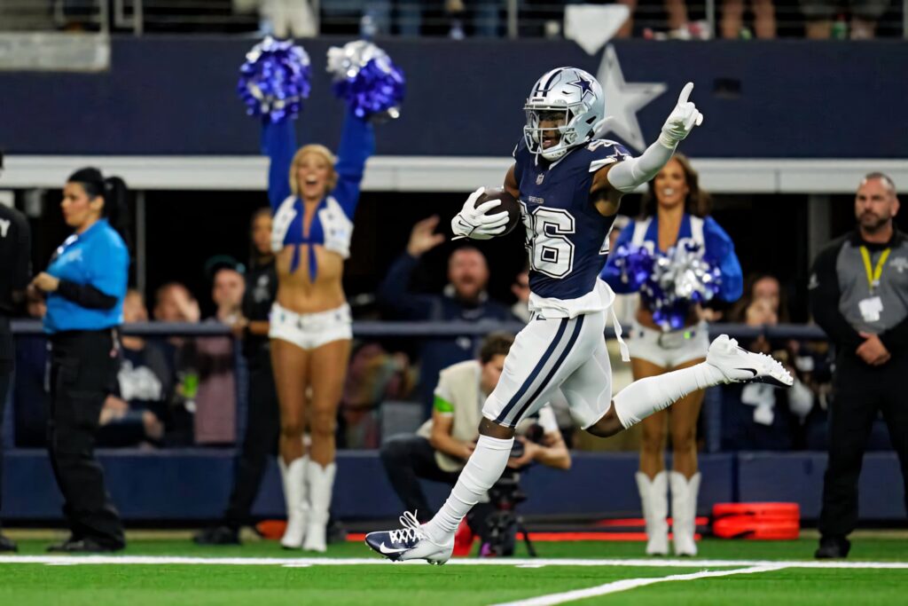 Daron Bland Dallas Cowboys touchdown celebration mid-stride on green field with cheering fans and cheerleaders Wallpaper