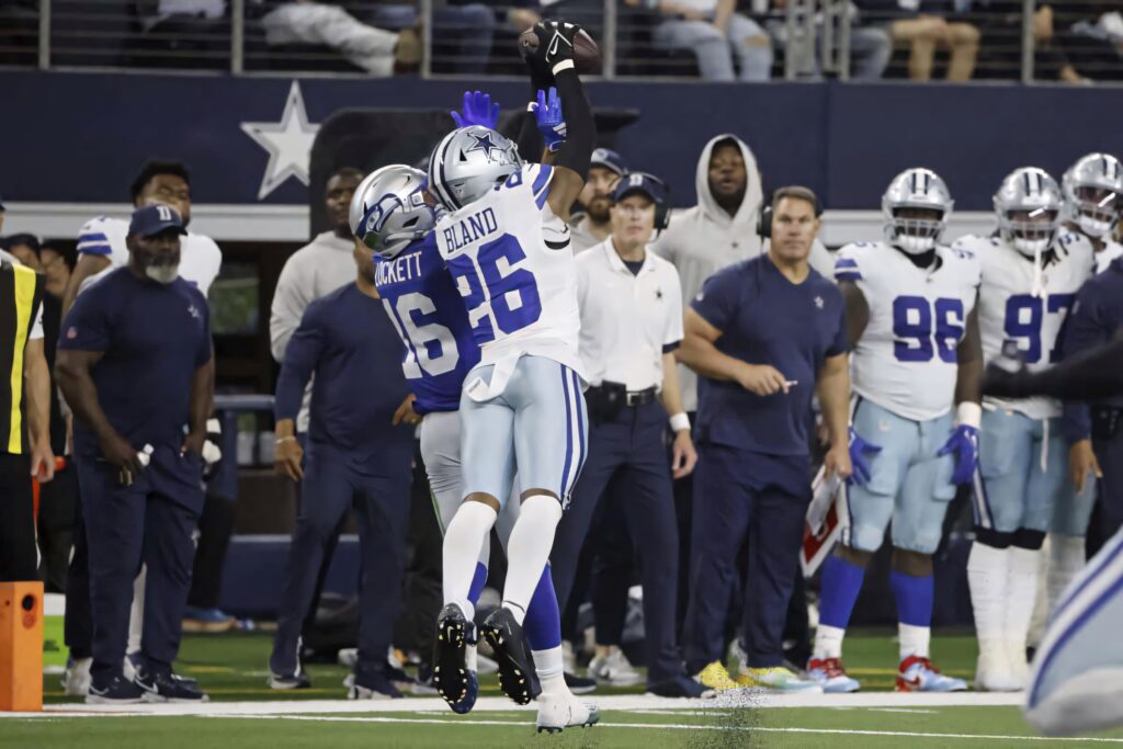 Daron Bland mid-air interception Dallas Cowboys football game intense athletic action stadium background Wallpaper