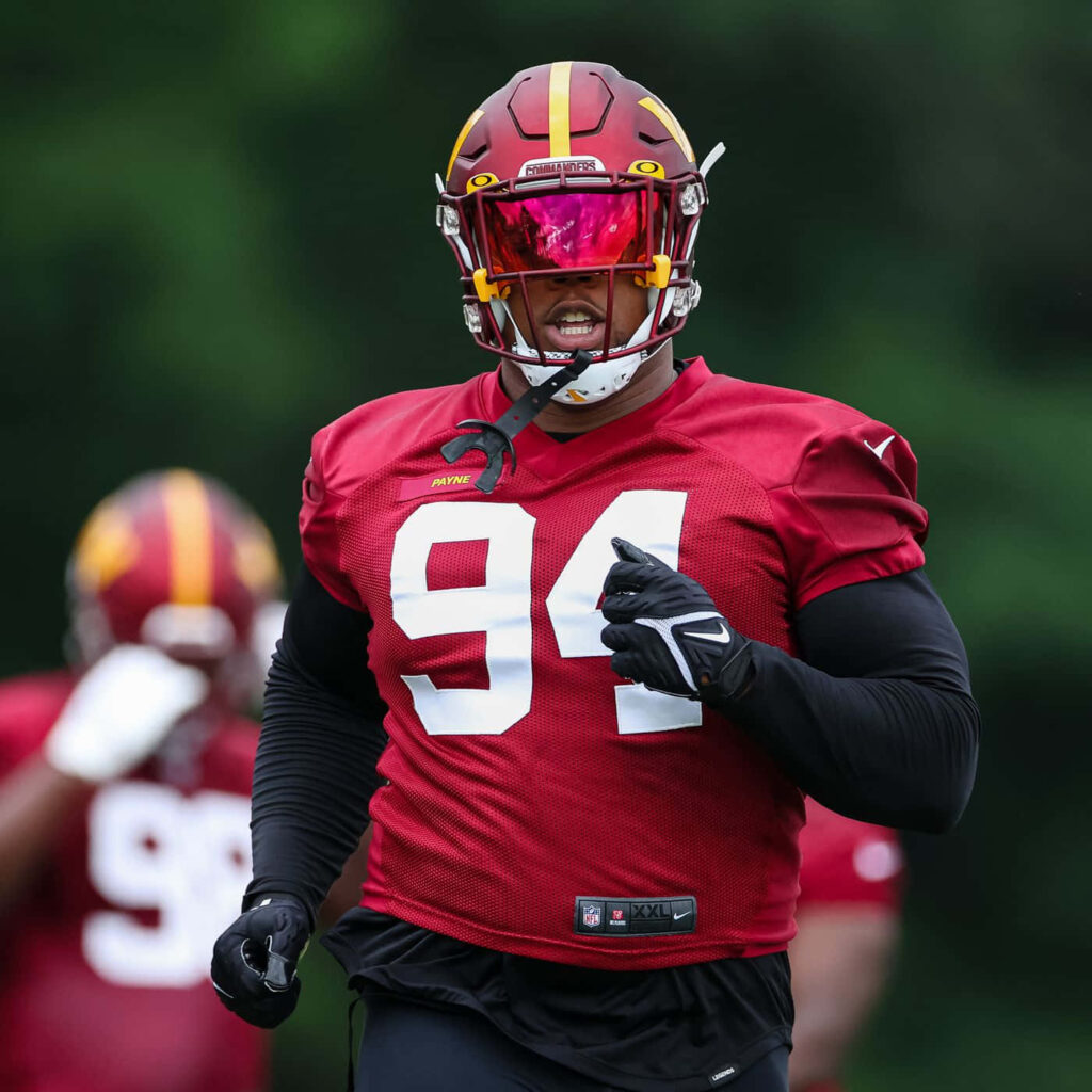 Daron Payne in red and gold jersey number 94 training with reflective visor intense football practice Wallpaper
