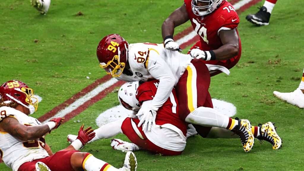 Daron Payne aggressive football tackle showcasing intense action and defensive skill on the field Wallpaper