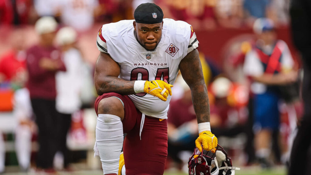 Daron Payne Washington Football Team intense defensive stance white burgundy uniform on field Wallpaper