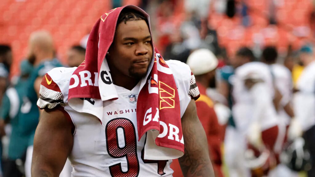Daron Payne Washington Football Team number 94 in white burgundy uniform confident on field Wallpaper