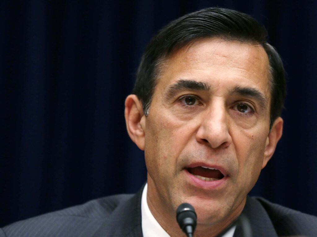Close-up photo of Darrell Issa in formal attire with expressive face on dark professional background Wallpaper