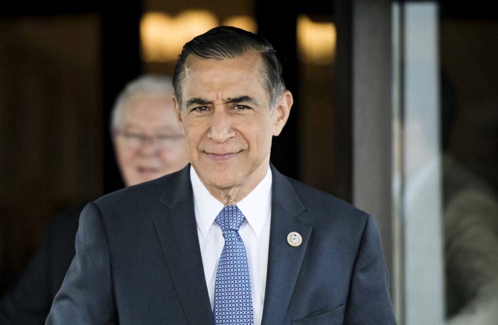 Darrell Issa in navy suit with patterned tie smiling confidently in professional portrait wallpaper