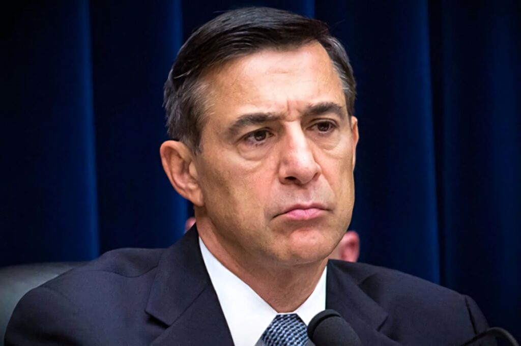 Portrait of Darrell Issa in sharp suit with serious expression on dark blue wallpaper background