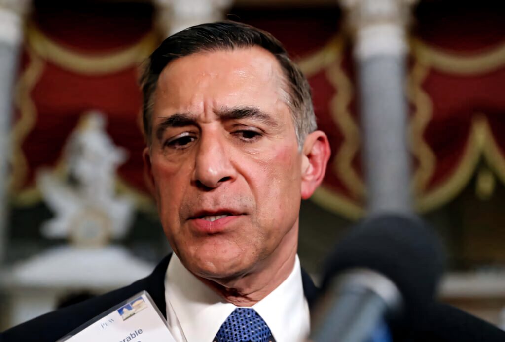Darrell Issa speaking at public event close-up with ornate red gold background formal atmosphere Wallpaper