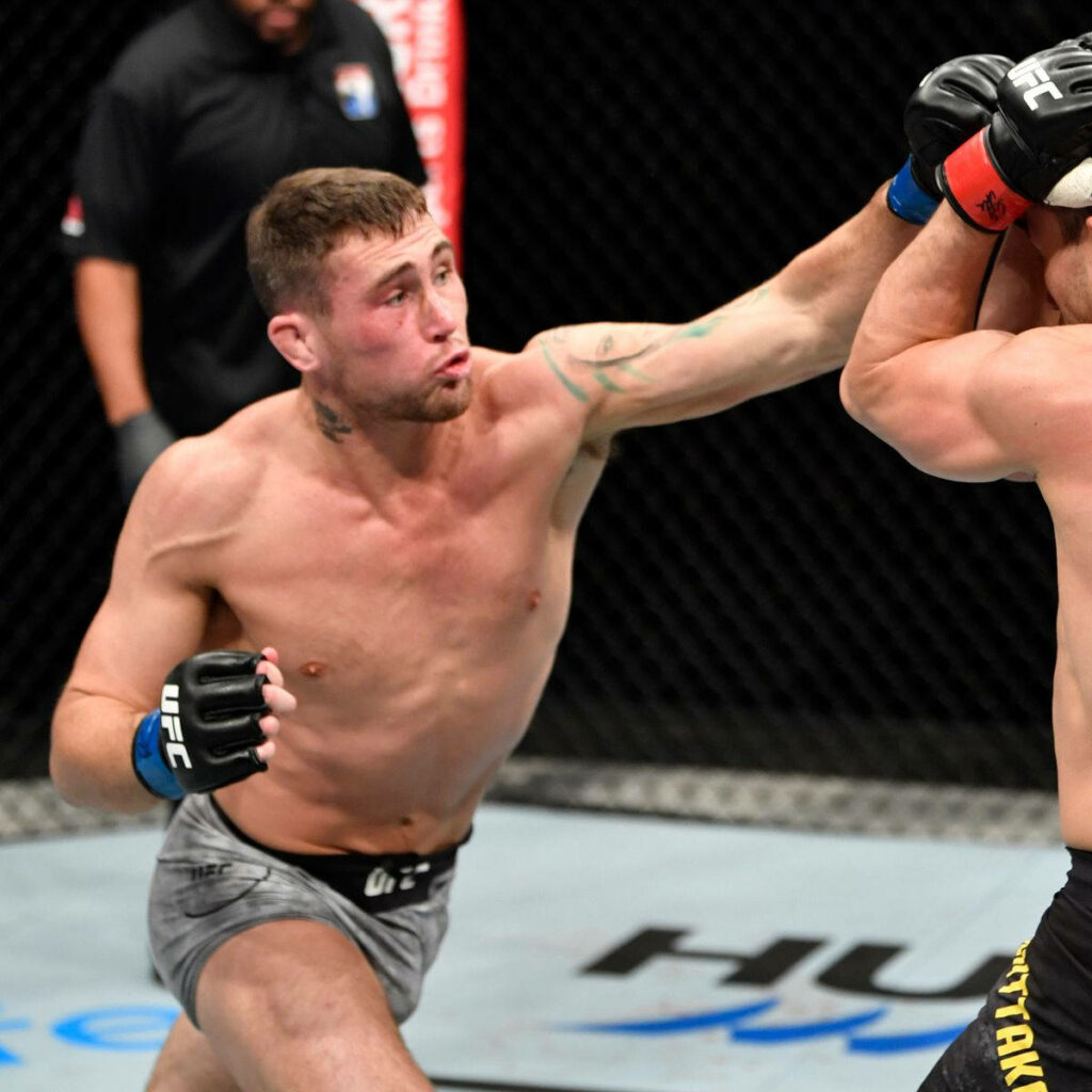 Darren Till landing powerful rising punch in UFC octagon showcasing strength and focus Wallpaper