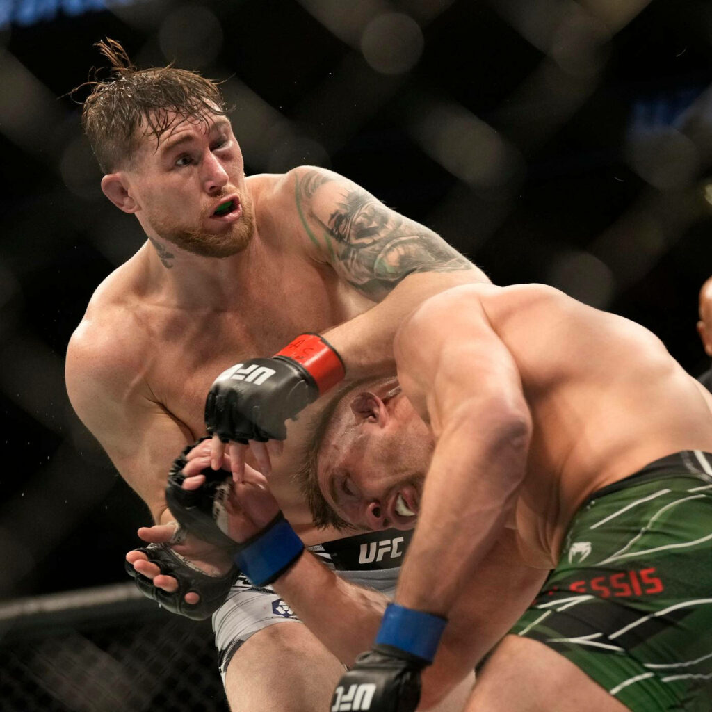 Darren Till mid UFC fight with black eye exchanging powerful blows showcasing MMA intensity Wallpaper
