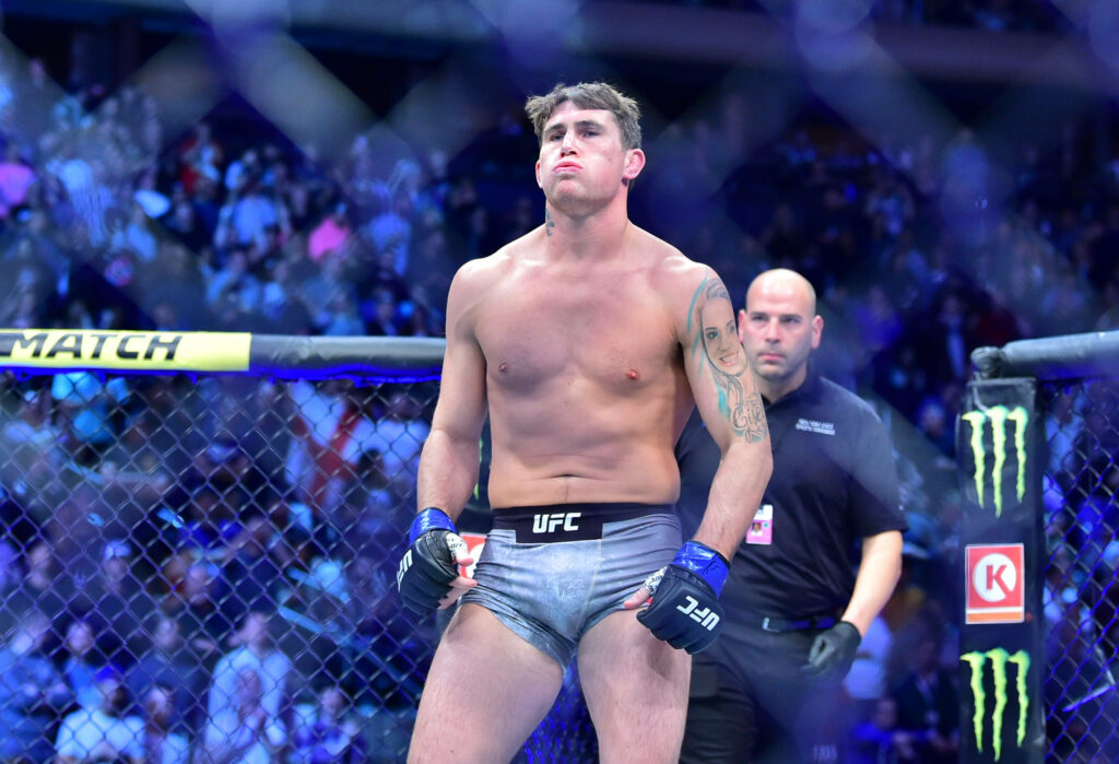 Darren Till focused in UFC octagon ready for MMA fight with intense crowd and arena lights Wallpaper