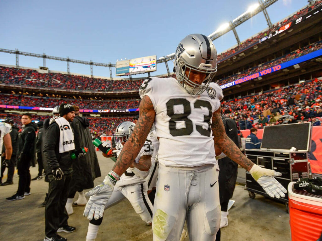 Darren Waller in Raiders uniform on stadium sideline showing athletic build and detailed tattoos Wallpaper