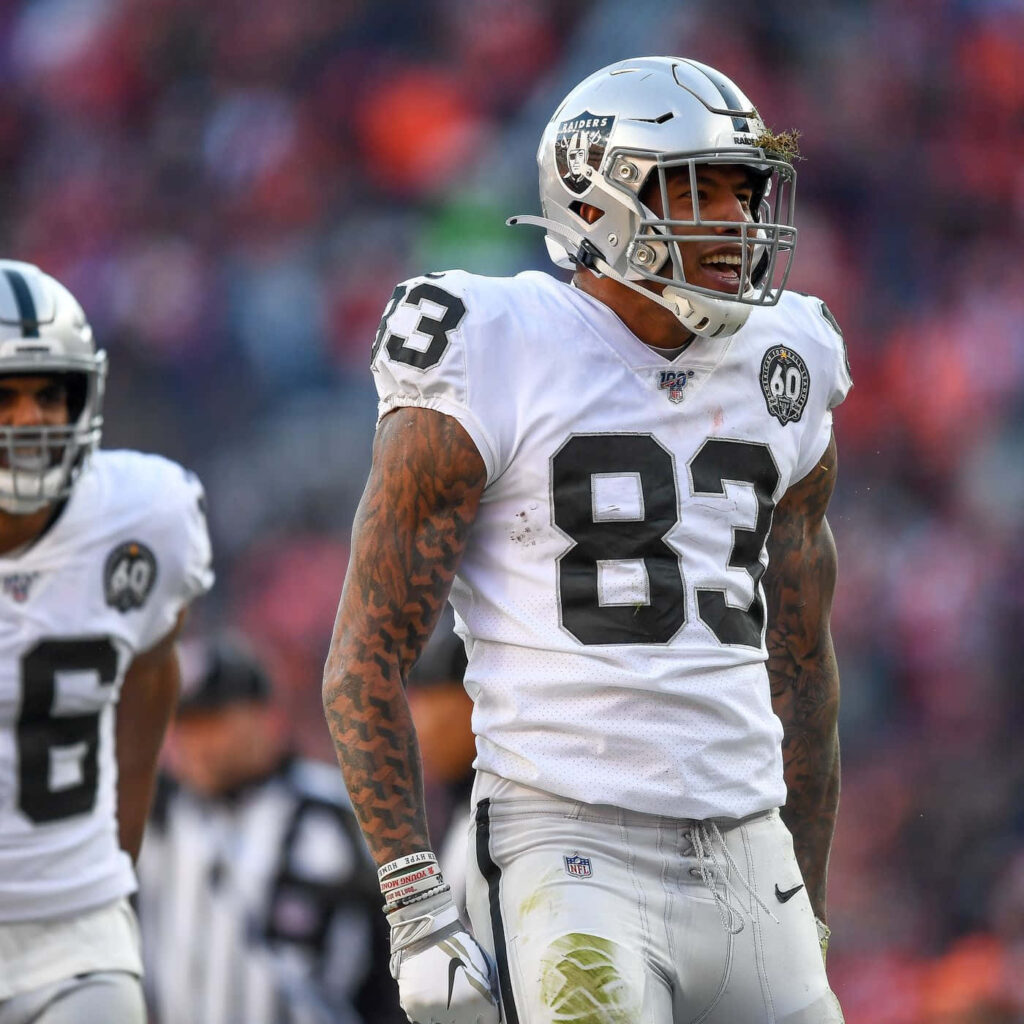 Darren Waller Raiders wallpaper showing NFL tight end with tattoos in vibrant stadium action