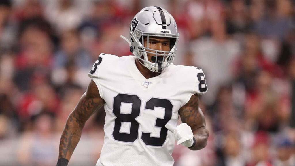 Darren Waller Raiders football player wallpaper in silver black uniform with blurred stadium background
