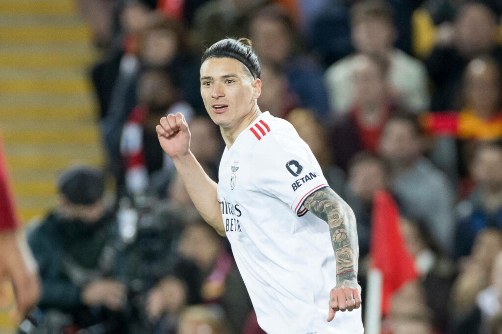 Darwin Núñez in white and red football kit sprinting on field with blurred fans background wallpaper