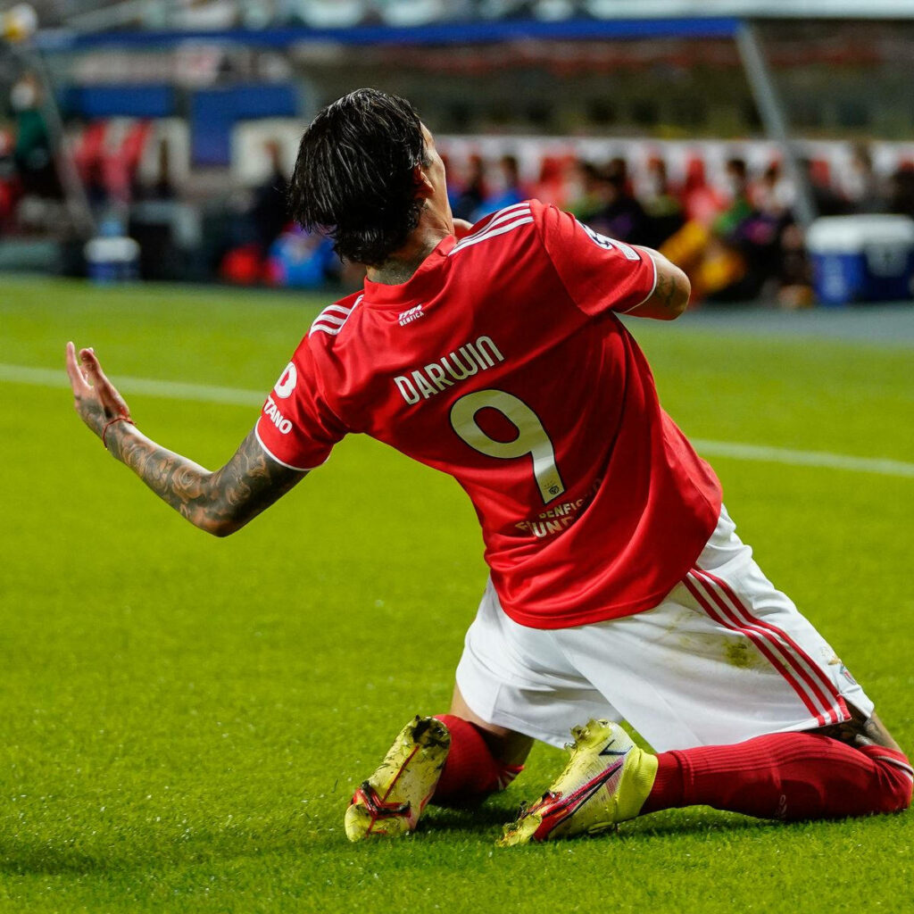 Darwin Núñez sliding celebration in red jersey number 9 on green pitch football wallpaper background