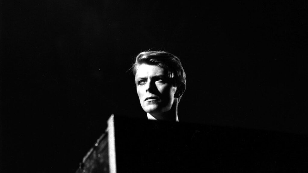 David Bowie greyscale wallpaper with dramatic lighting dark background iconic style portrait