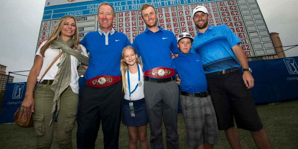 David Duval with family and friends wearing championship belts in front of golf scoreboard smiling Wallpaper