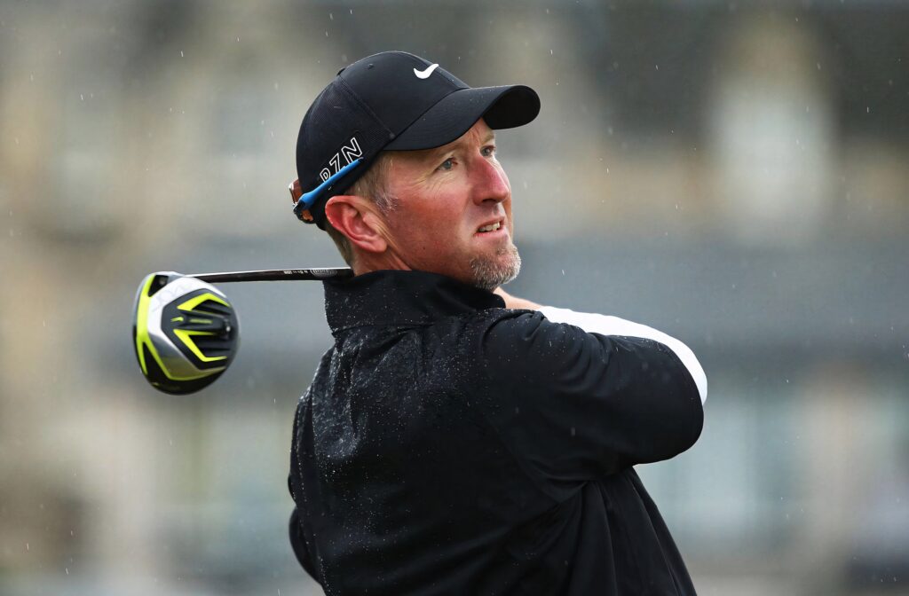 David Duval mid golf swing with raindrops dark sporty gear blurred golf course background wallpaper