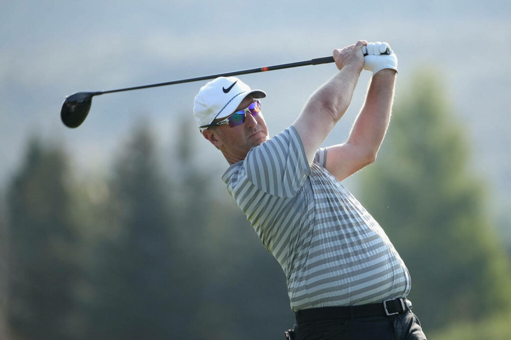 David Duval mid-swing golf wallpaper focused expression athletic form blurred nature background