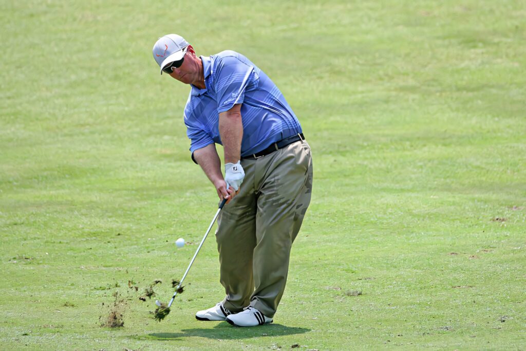 David Duval mid-swing on vibrant green golf course wearing blue shirt and khaki pants golf wallpaper