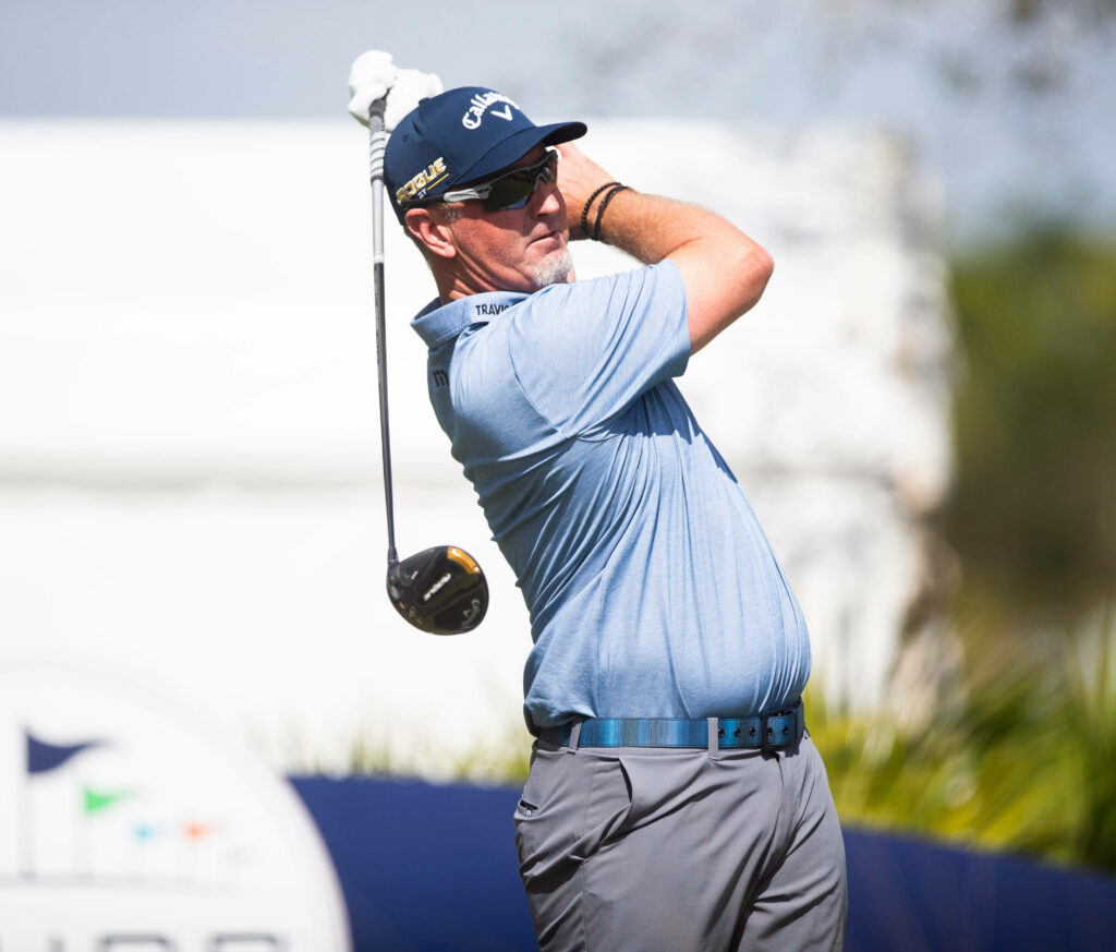 David Duval mid-swing in light blue shirt on sunlit golf course showcasing focus and athleticism Wallpaper