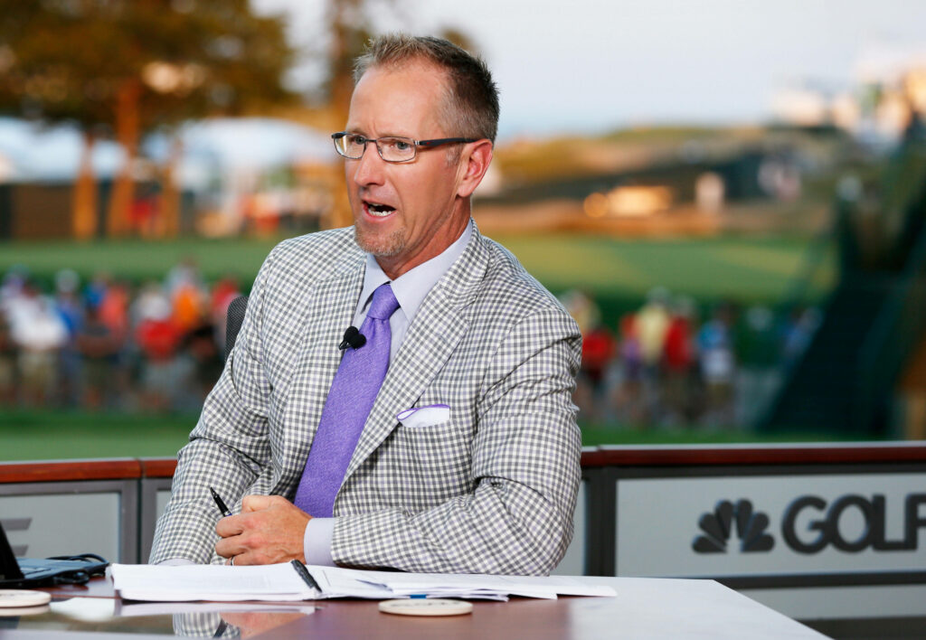 David Duval in plaid suit and lavender tie at broadcast desk with vibrant golf course background Wallpaper